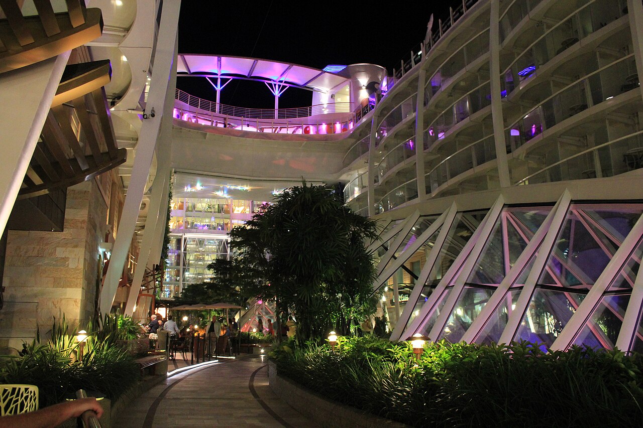 Central Park at night on Oasis of the Seas, with inward-facing balconies above a planted walkway